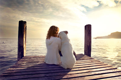 end-of-life-care dog rests gently on women shoulder while looking view